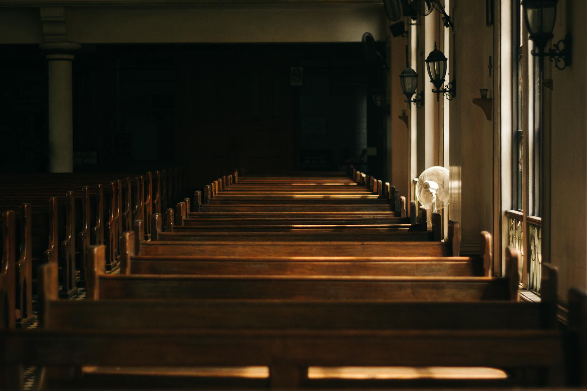 brown wooden church bench near white painted wall